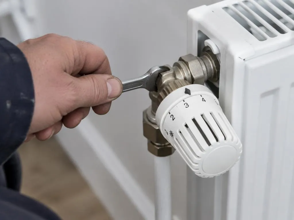 Engineer bleeding or repairing a radiator, gas central heating service/repair in Hampshire